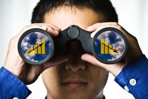 A businessman looking through binoculars, seeing conflicting trends in earnings prediction, can be used for business vision or business prediction concept